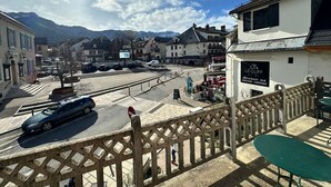 A town square with a restaurant named 'LE CLIFF' and a view of mountains in the background. - Bright duplex in the heart of Villard, 5 pax (Villard-de-Lans)