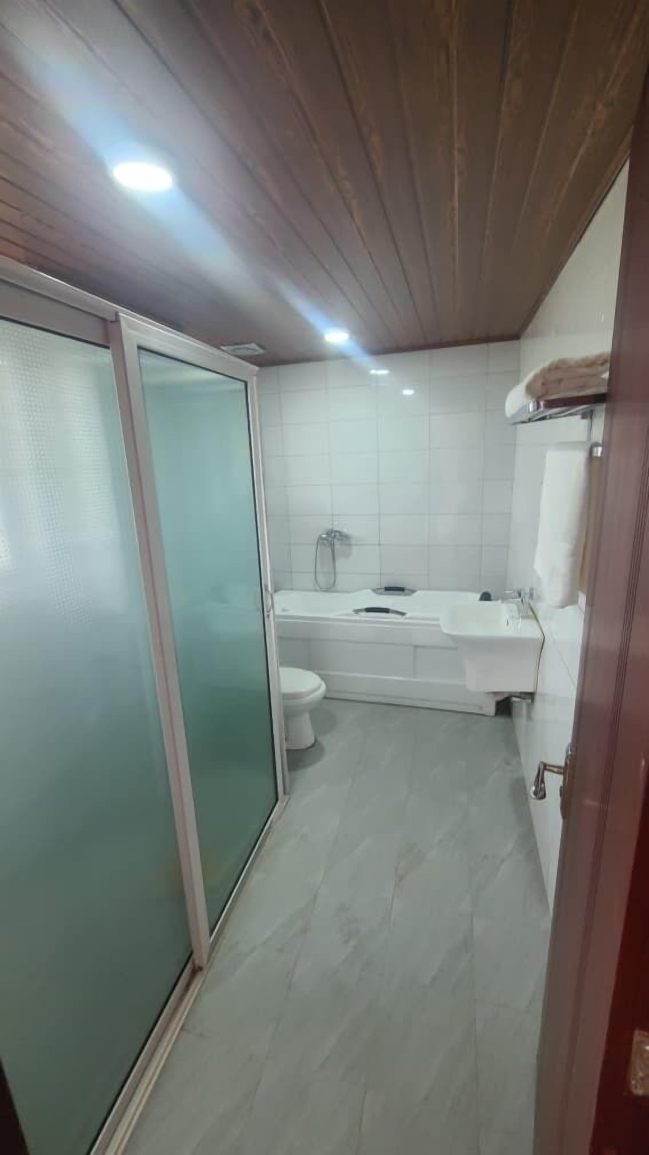 Et badeværelse med toilet, vask og bruser.