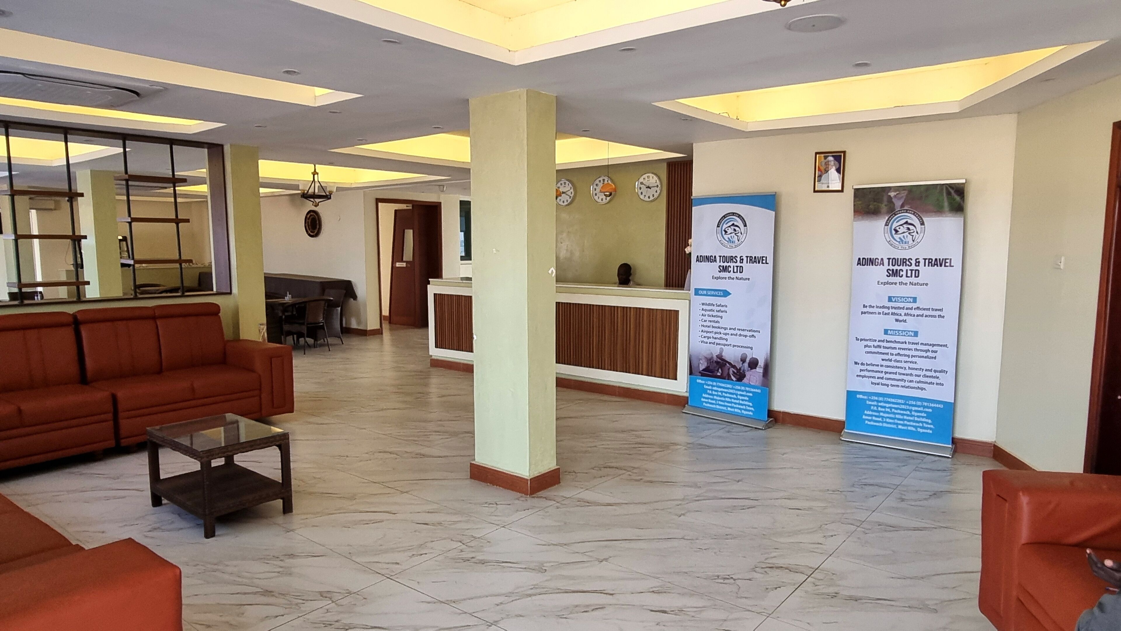 A lobby with a reception desk, a sofa, and a coffee table. There are two large vertical banners on the wall.
