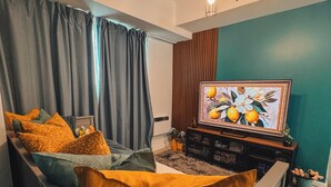 A modern living room with a sofa, a TV, and a painting. - Luxury Penthouse in CBD w/ Wave Pool, 7ft Billiards & Wide Balcony for Getaways (San Fernando)