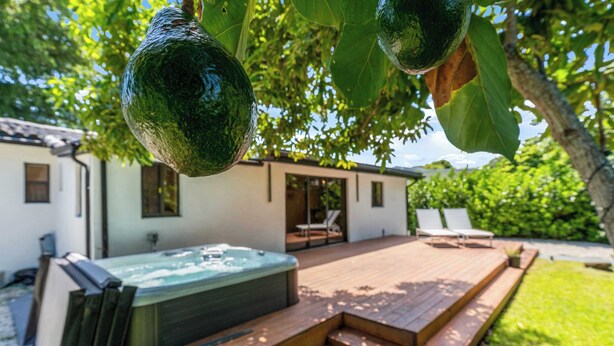 Ein Whirlpool, eine Holzterrasse und ein Haus mit einer Terrasse.