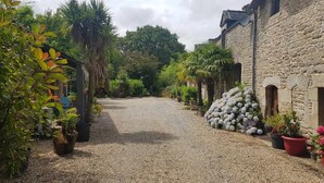 A cobblestone alley with potted plants and a stone building. - Comfortable gite in the beautiful Brittany countryside (Bignan)