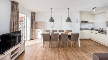 A modern apartment with a dining area, kitchen, and living room.