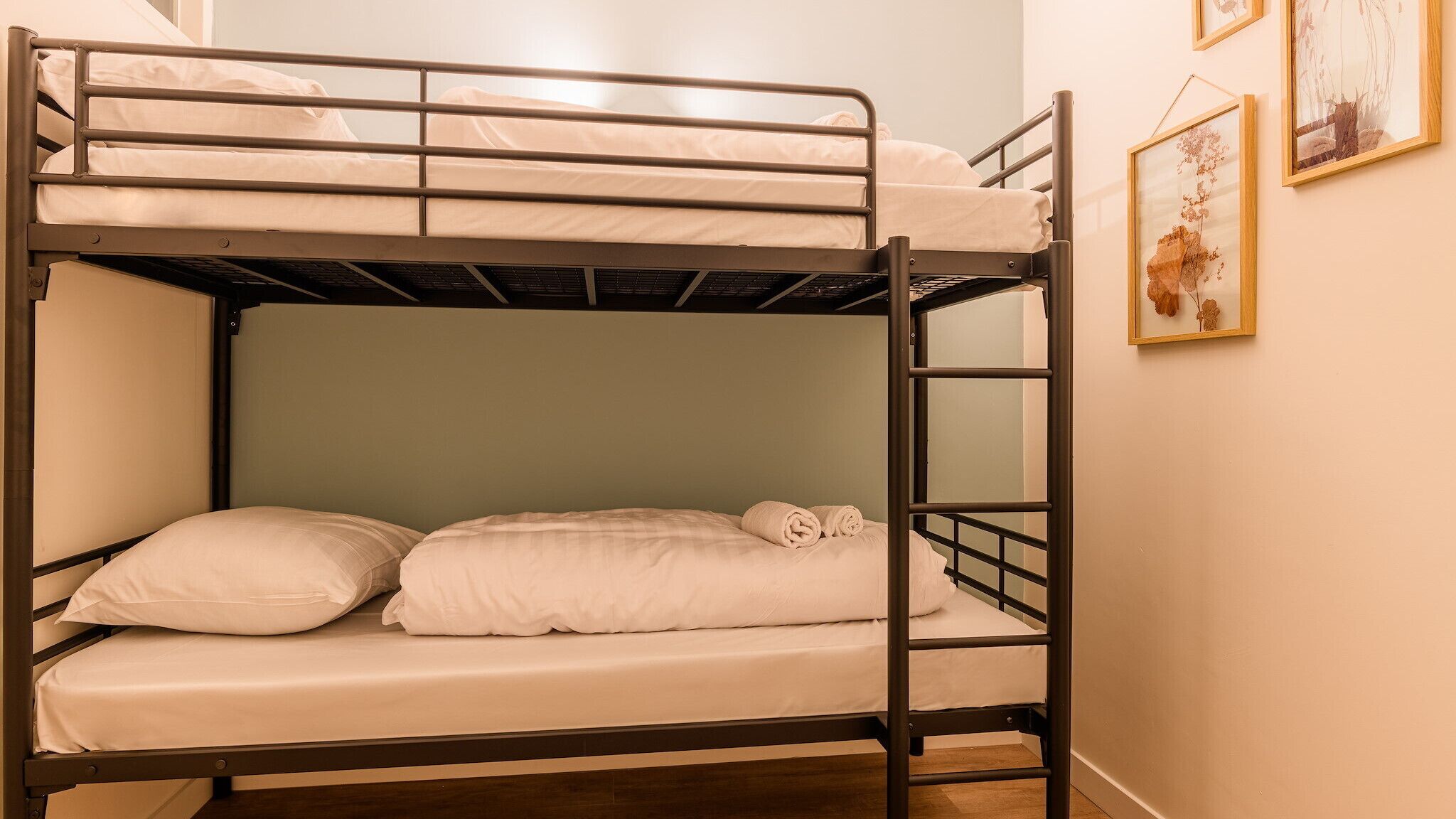 Un lit superposé à deux niveaux, chaque niveau étant équipé d’un matelas et d’oreillers.