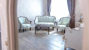 A room with three upholstered chairs, a small table, and a white dresser. - Anapea Village (Kvareli)