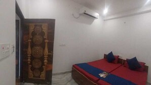 Un dormitorio con una cama, una puerta de madera y un equipo de aire acondicionado.