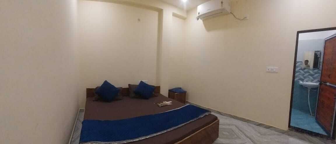 Un dormitorio con cama, almohadas, una mesita de noche y un espejo.