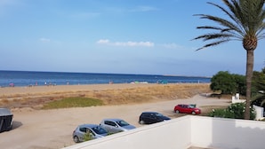 A beach with parked cars and a palm tree. - Casa Playa Direct (Dénia)
