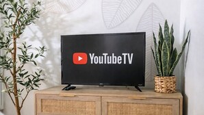 Logotipo de YouTube TV en una pantalla de televisión negra ubicada sobre un mueble de madera con cajones.