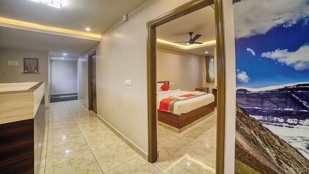 Una habitación de hotel con una cama, un baño con tocador y un mural de un paisaje montañoso.