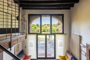 A staircase leading to a balcony with a view of a garden.