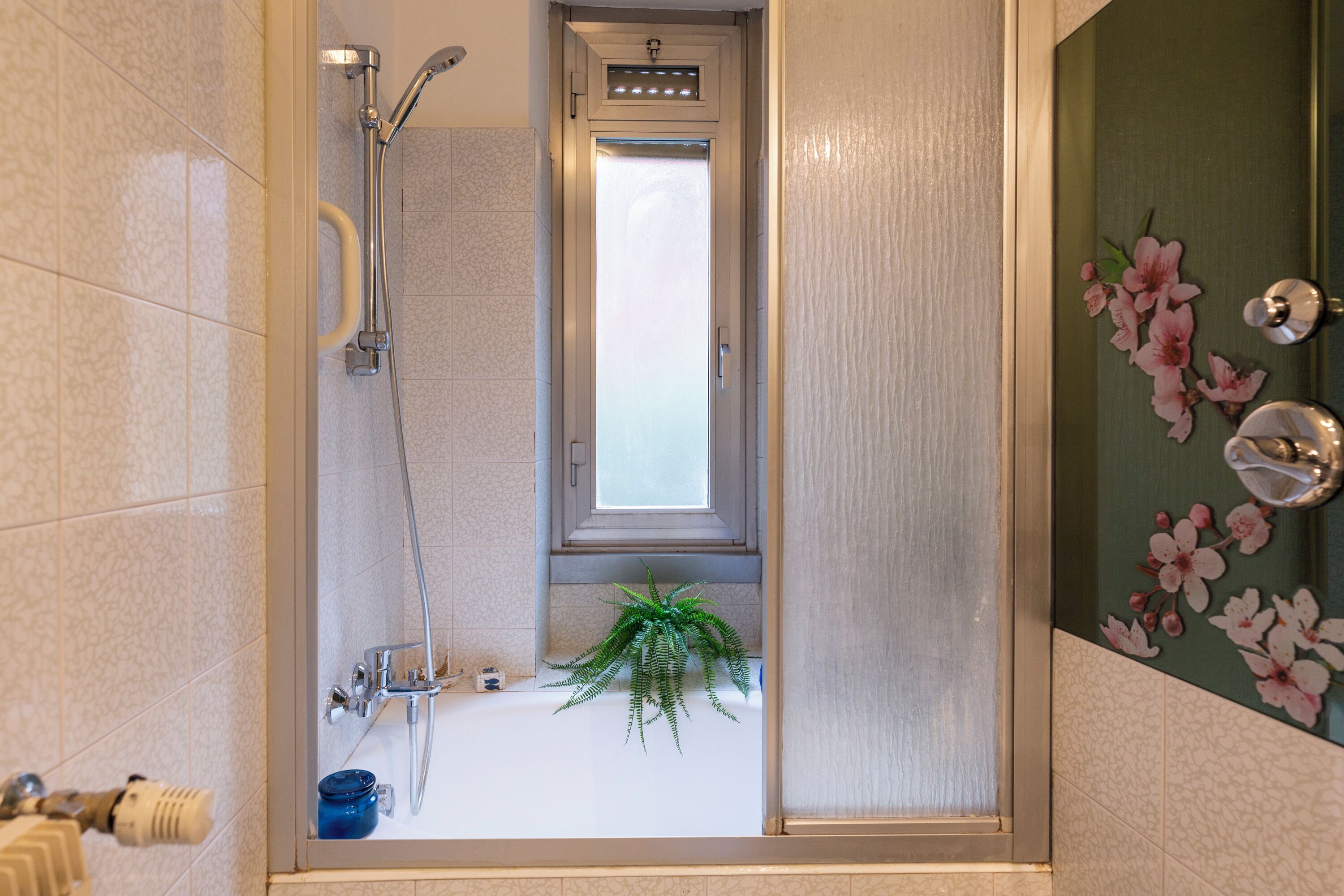 Un baño con ducha, lavabo y ventana.