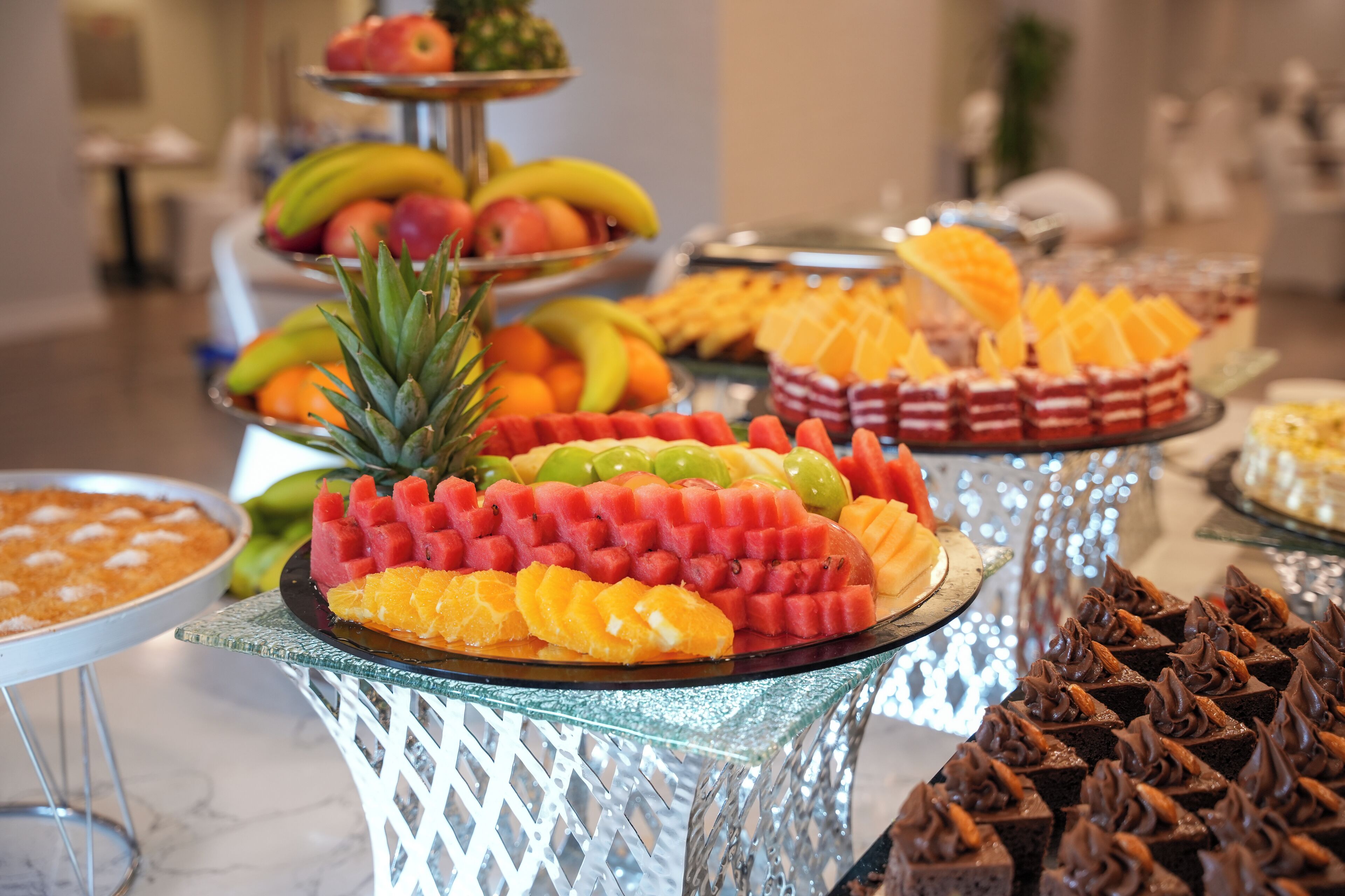 Un bufé con diversas frutas y postres.