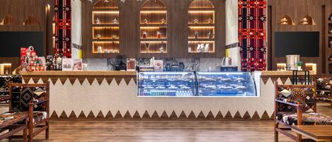 A bar area with wooden shelves, a display case, and patterned chairs.
