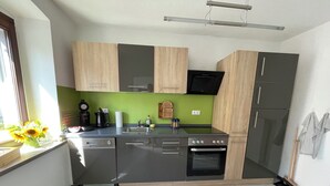 Eine moderne Küche mit grauen und hölzernen Schränken, einem eingebauten Backofen und einem Geschirrspüler.