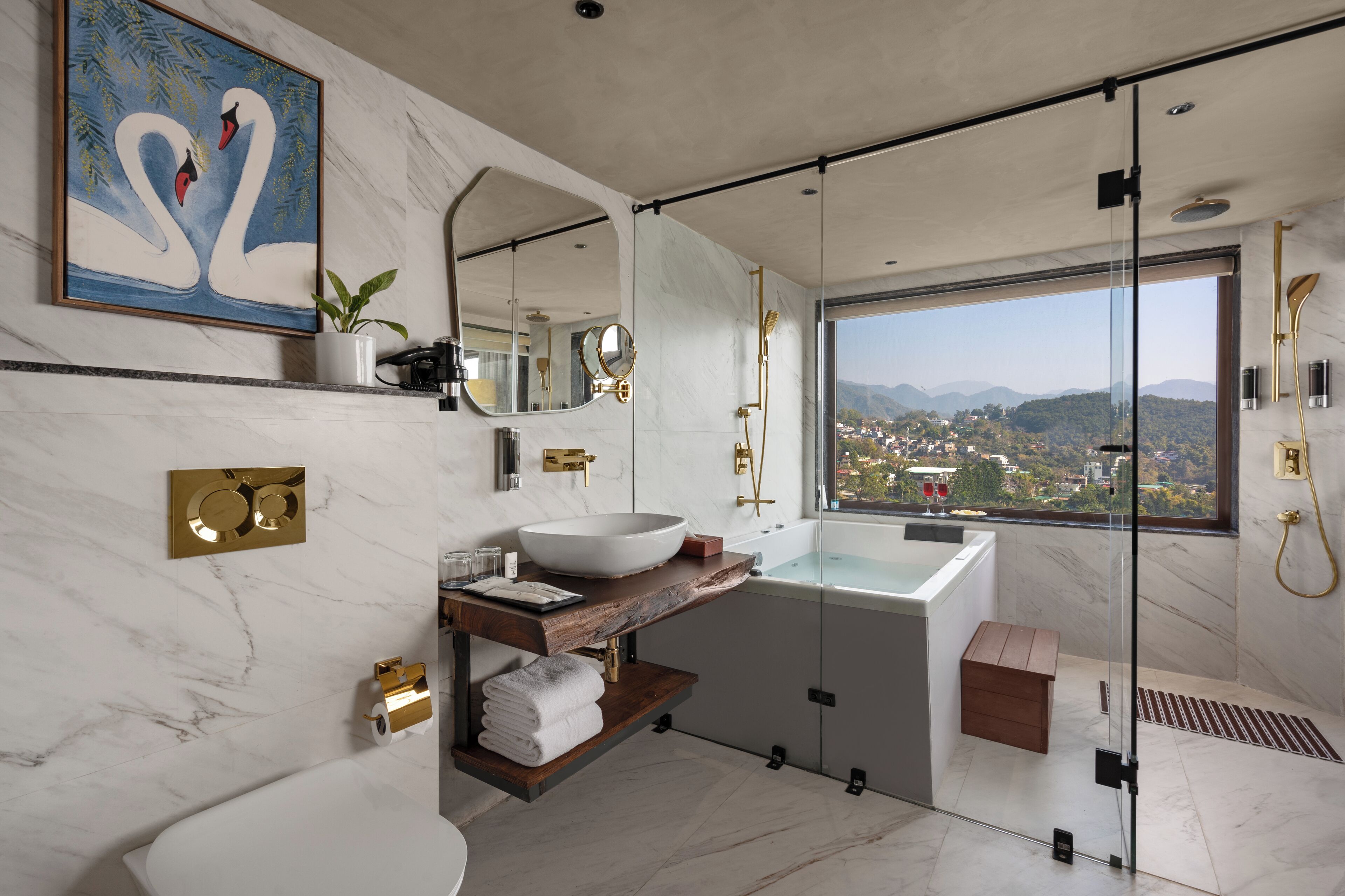 A modern bathroom with a large window, a marble sink, and a glass-enclosed shower.