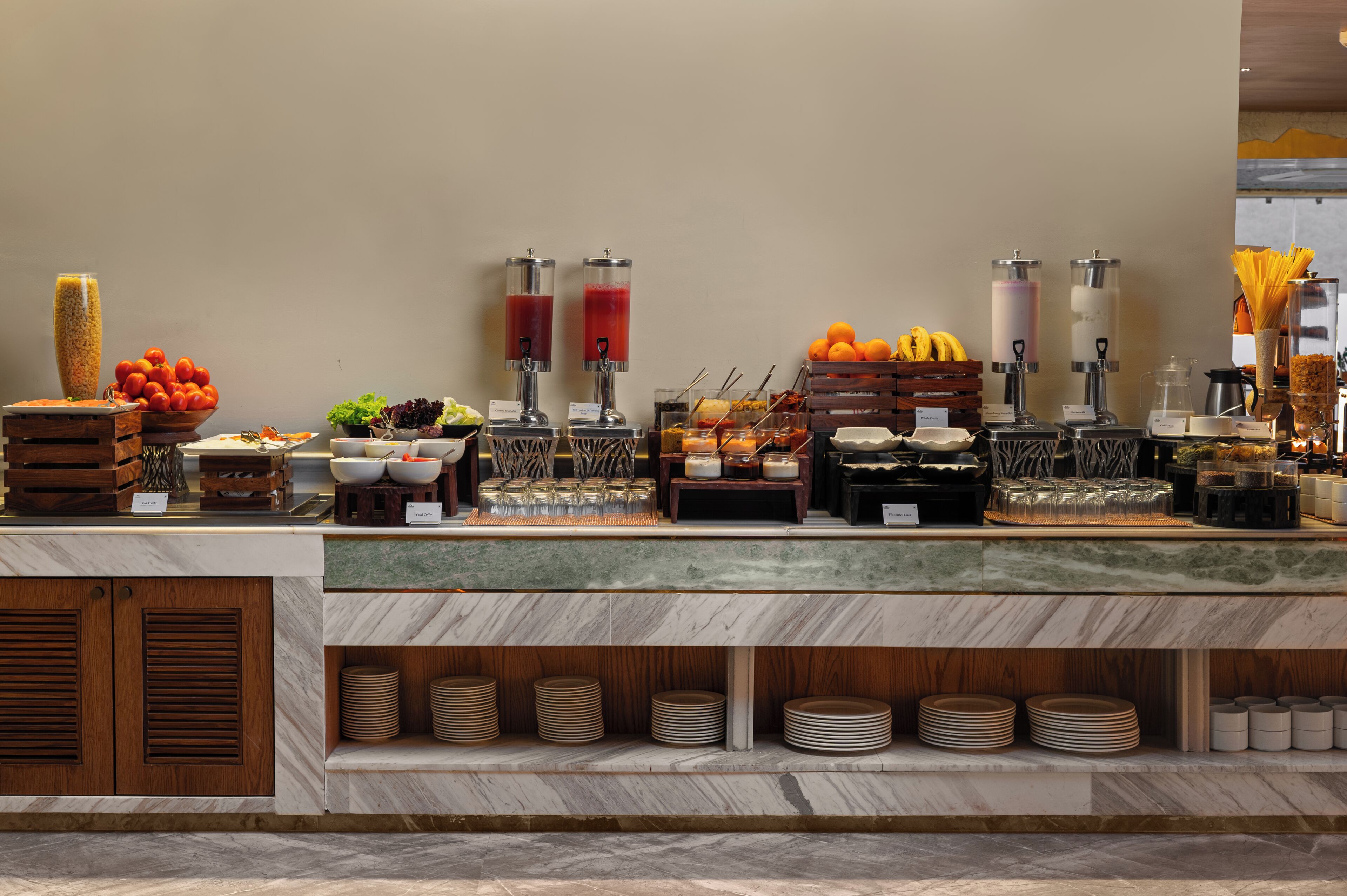 Un'attrezzatura per buffet con diverse pietanze, tra cui frutta, verdura e bevande.