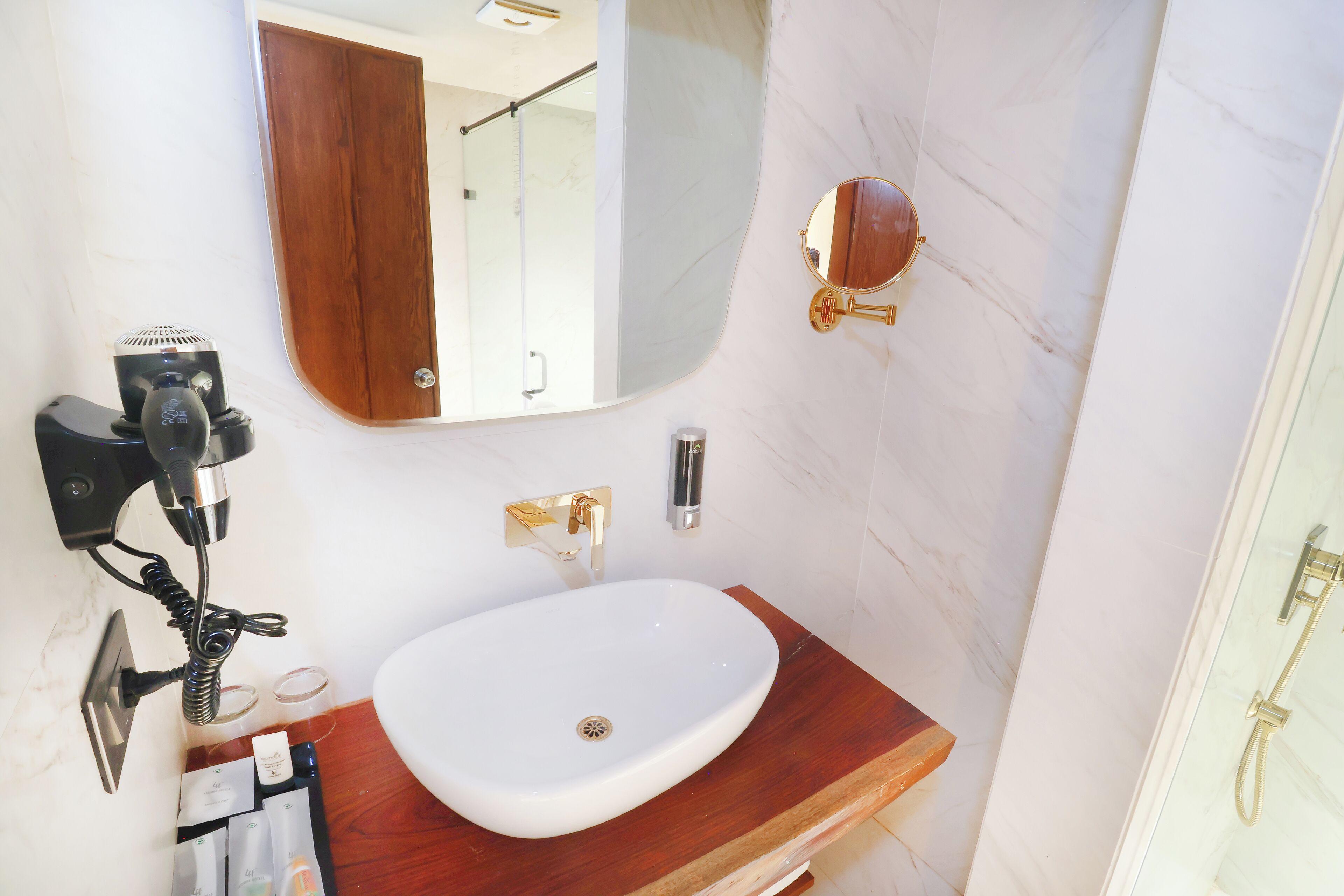 A bathroom with a white sink, wooden countertop, and a mirror.