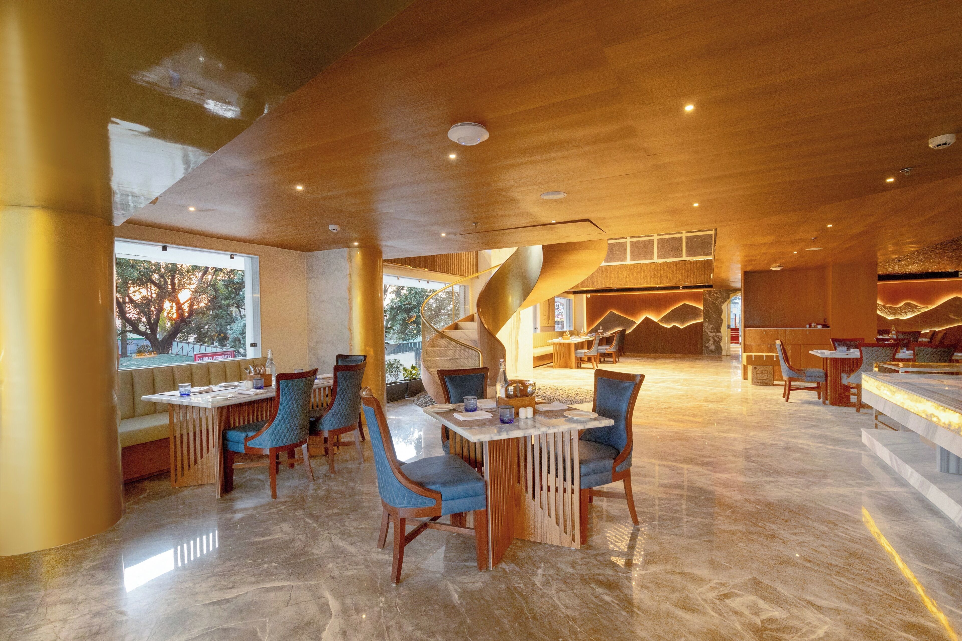 Un comedor espacioso con una isla central, techo de madera y amplios ventanales.