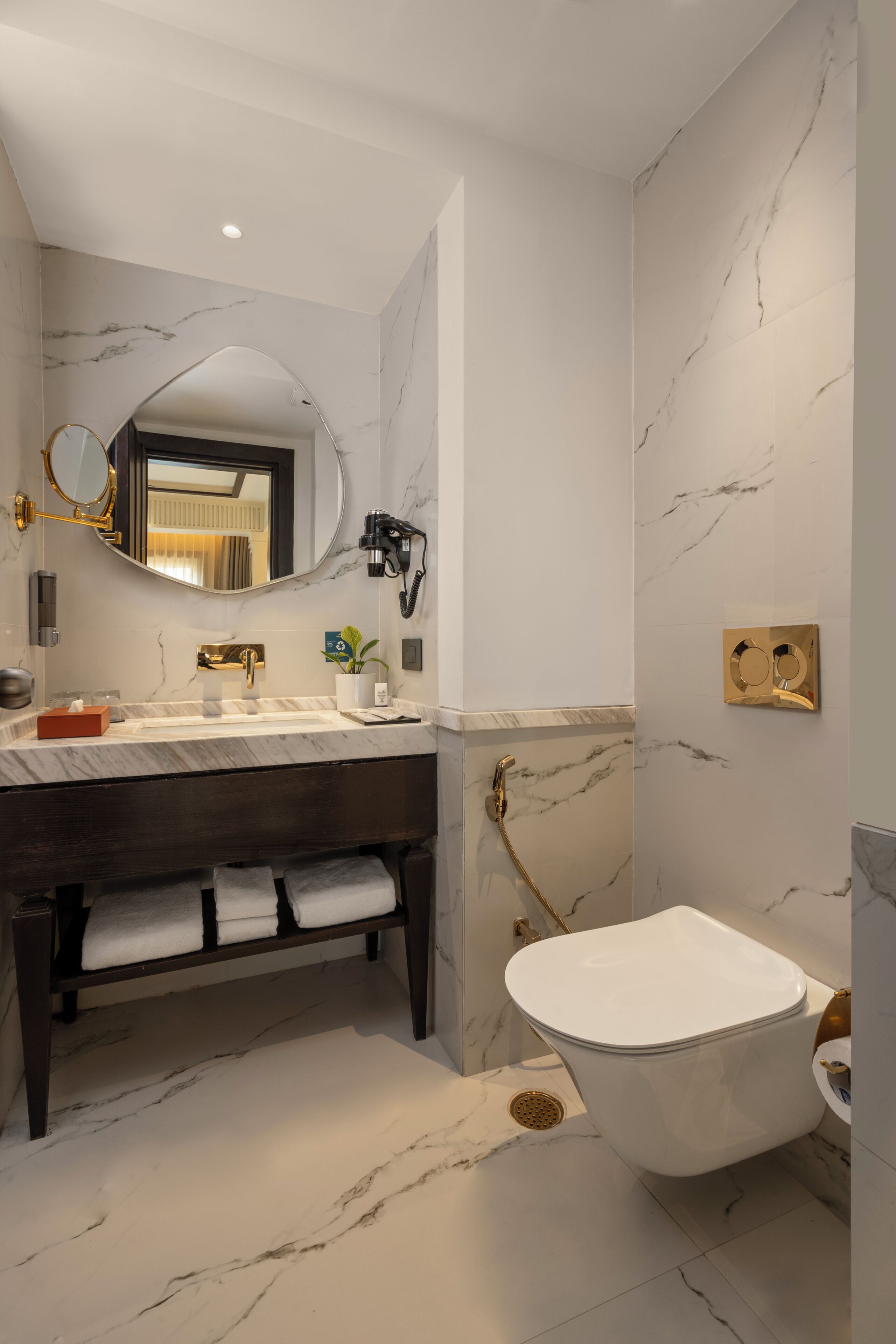 A bathroom with a marble vanity, a toilet, and a shower.