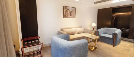 A modern living room with a sofa, armchair, and a small table.