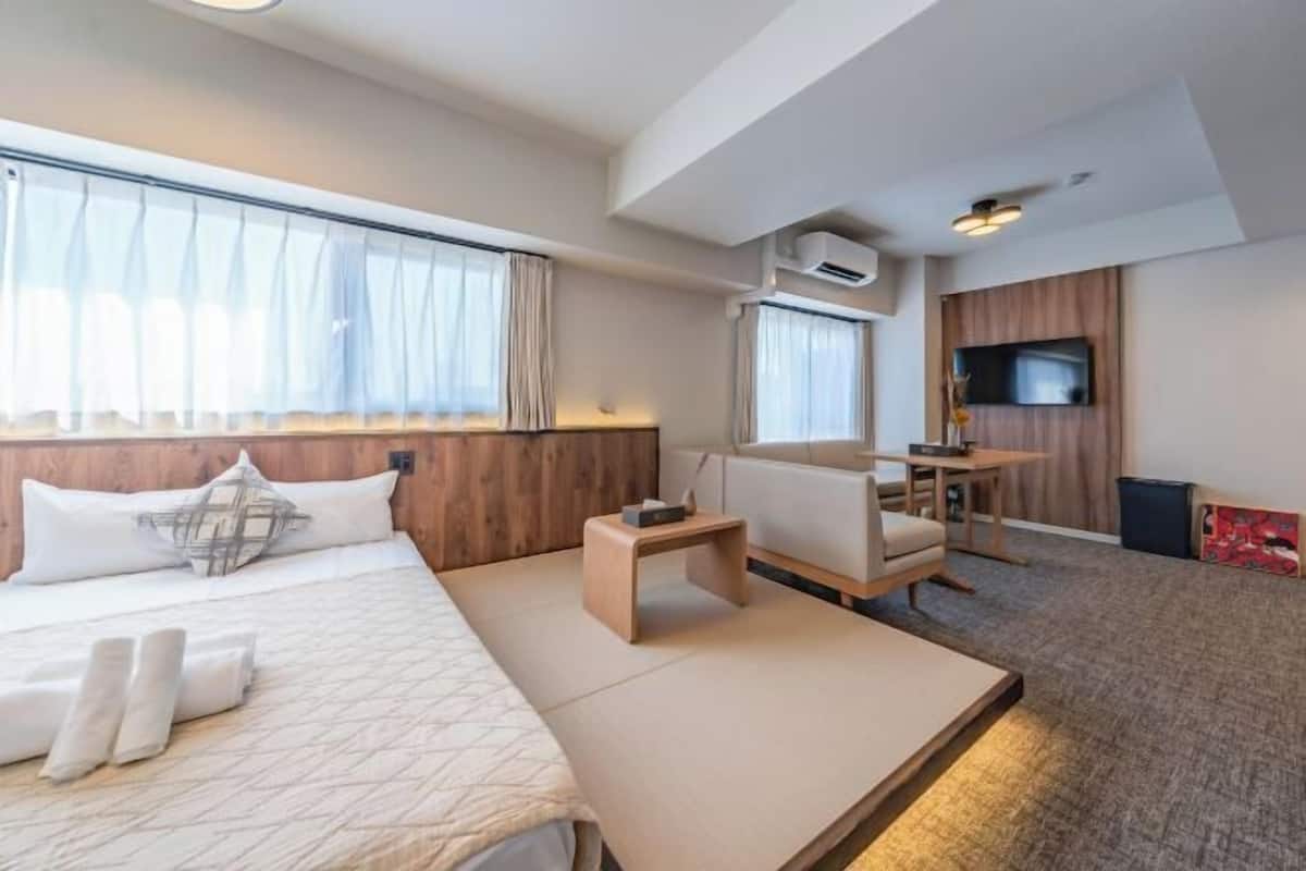 Une chambre d’hôtel équipée d’un lit, d’une petite table, d’un canapé, d’une télévision et d’un appareil de climatisation.