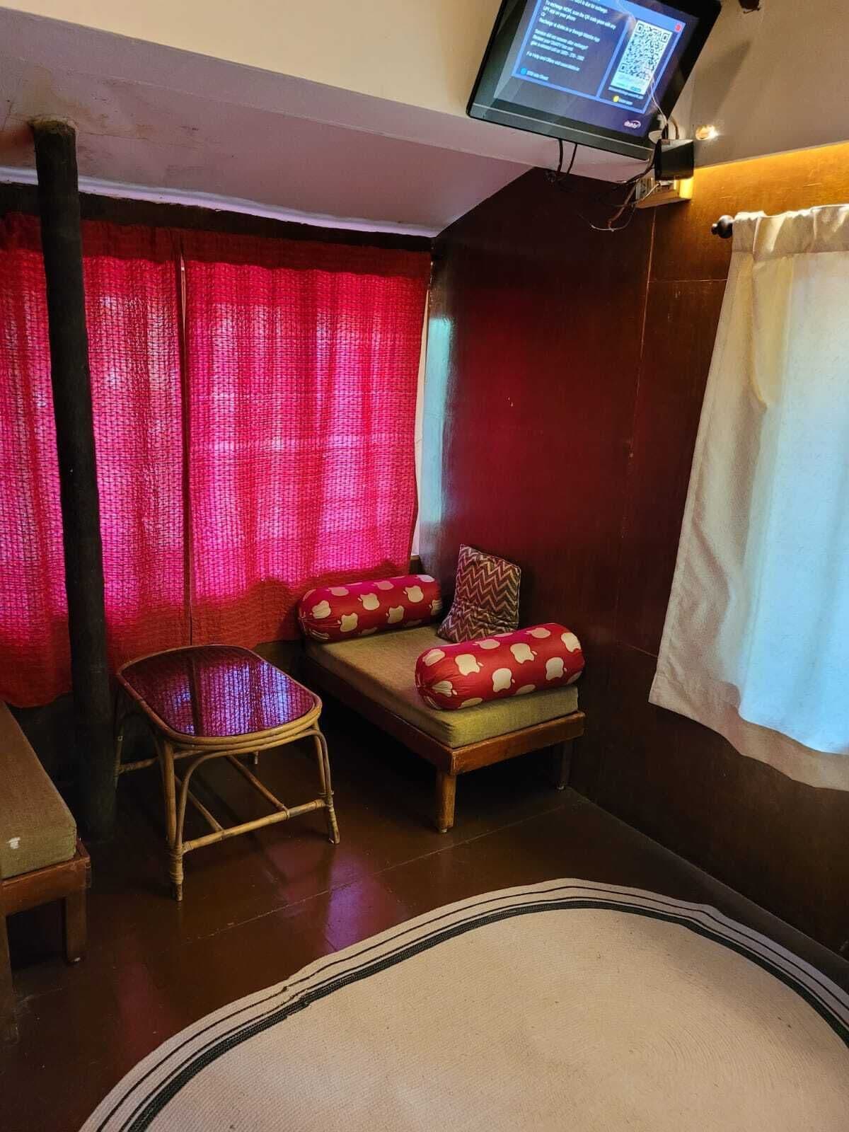A room with a sofa, a small table, and a television mounted on the wall.