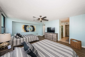 A hotel room with two beds, a TV, a ceiling fan, and artwork on the wall. - 2BR waterfront condo with balcony, pool, hot tub, and beachy views. (St. Petersburg)