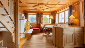 Ein Holzblockhaus-Interieur mit Essbereich, einer Bank und einer Küchenarbeitsfläche.