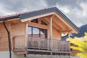 A wooden building with a balcony, large windows, and a red-tiled roof. - Inzell Chalets With Private Pool (Inzell)