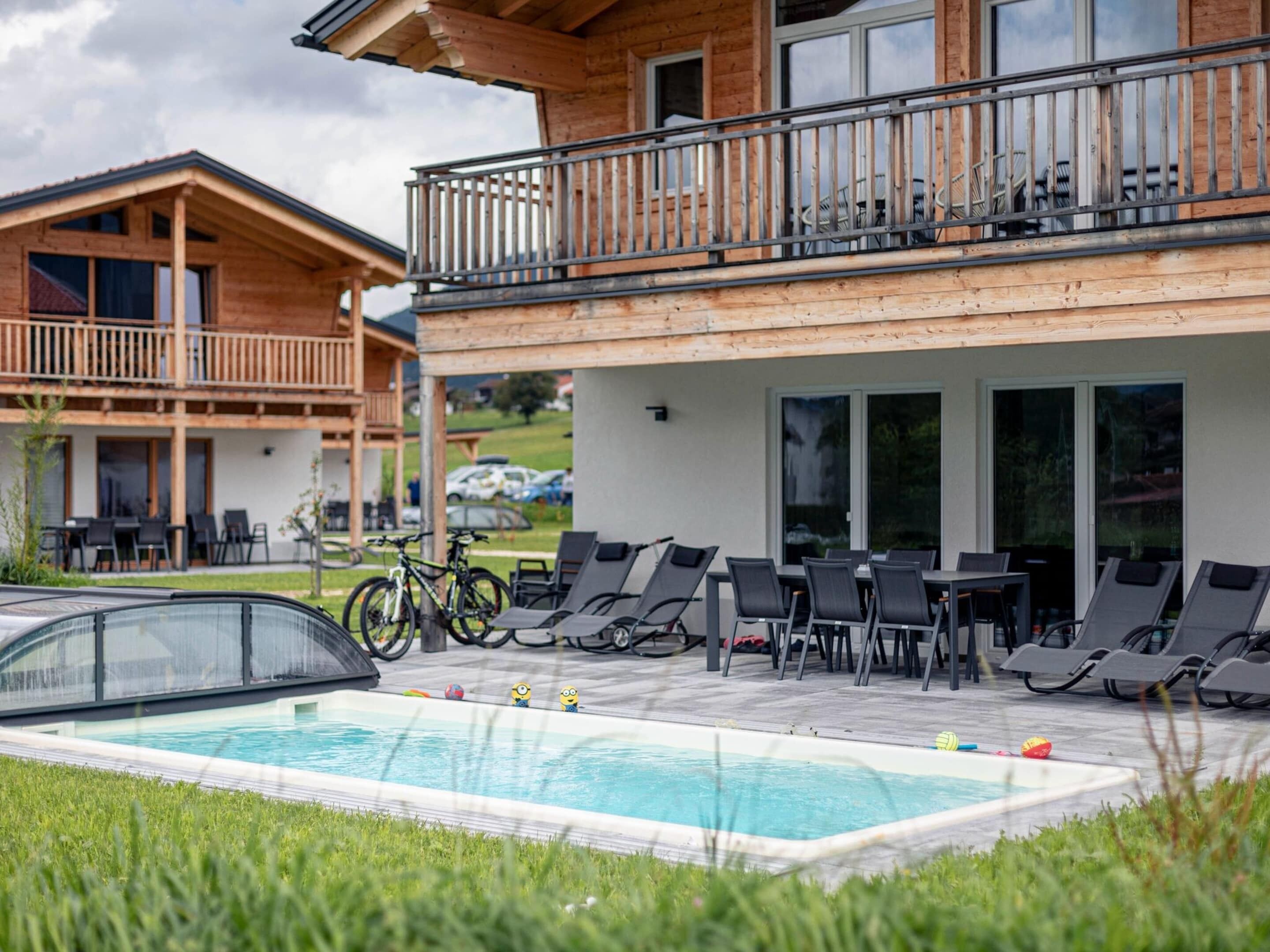 A pool area with lounge chairs and a bicycle.