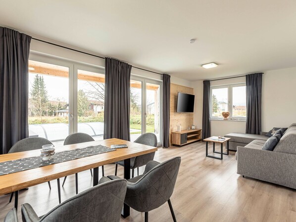 Relax in a spacious living area with a dining table, sofa, and flat-screen TV.