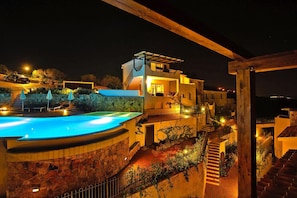 A modern villa with a swimming pool, outdoor seating, and a staircase leading to the upper levels. - Apartment in Golfo Aranci With Terrace (Arzachena)