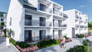 A modern multi-story residential building with balconies, a paved walkway, and landscaped gardens. - Comfortable 2-room Apartment Only 450 m From the Beach, Grzybowo (Kołobrzeg)
