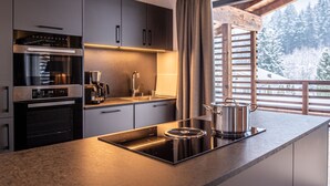 Une cuisine moderne équipée d’un four encastré, d’une machine à café et d’une cuisinière.