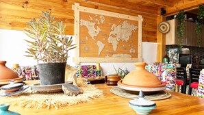 Un interior de madera con un mapa mundial, macetas de terracota y cestas tejidas.