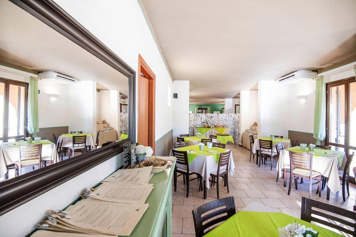 A restaurant with multiple tables, chairs, and a counter with menus.