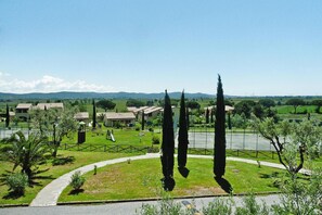 A residential area with houses, a playground, and tall cypress trees.