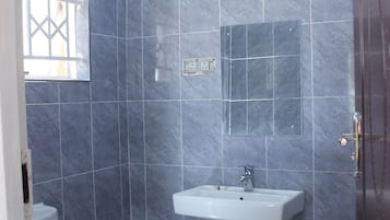 Een douche, handdoeken, zeep, toiletpapier