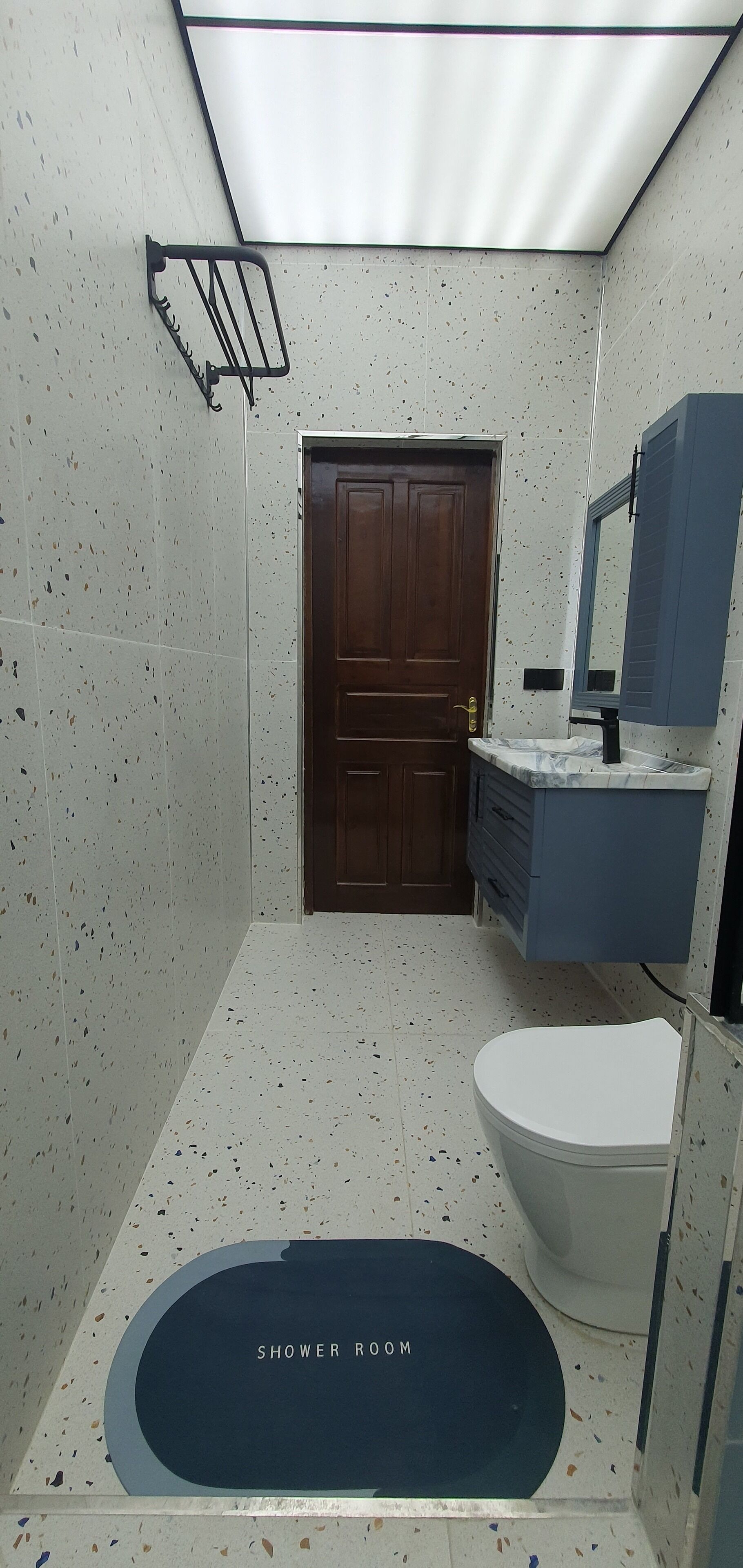 Um banheiro pequeno e compacto, com chuveiro, vaso sanitário e pia com espelho.