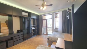 A modern bedroom with a large wardrobe, a bed, and a balcony with a view. - The Pearl of Nizami Street (Baku)