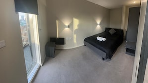 A modern bedroom with a curved ceiling, a large bed, bedside tables, and wall-mounted lighting. - Apartment - Sleeps 4, Pets Allowed & Free Parking (Manchester)