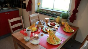Una mesa de desayuno con diversos alimentos, bebidas y una vela.