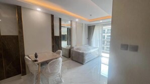 Una habitación de hotel con una cama, una mesa y sillas cubiertas de plástico.