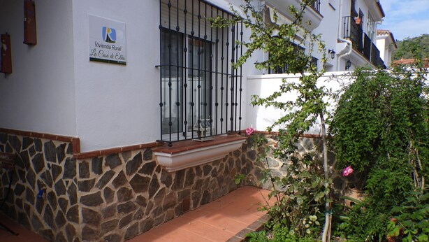 A building with a stone foundation, a tiled patio, and a sign indicating it is a rural living space.