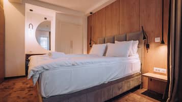 Un dormitorio moderno con una cama grande, paneles de madera, un banco empotrado y un espejo.