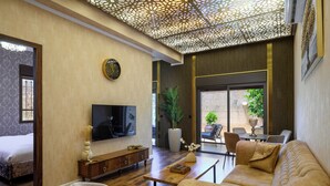 Un soggiorno moderno con divano, poltrona, televisore e un elegante consolle.