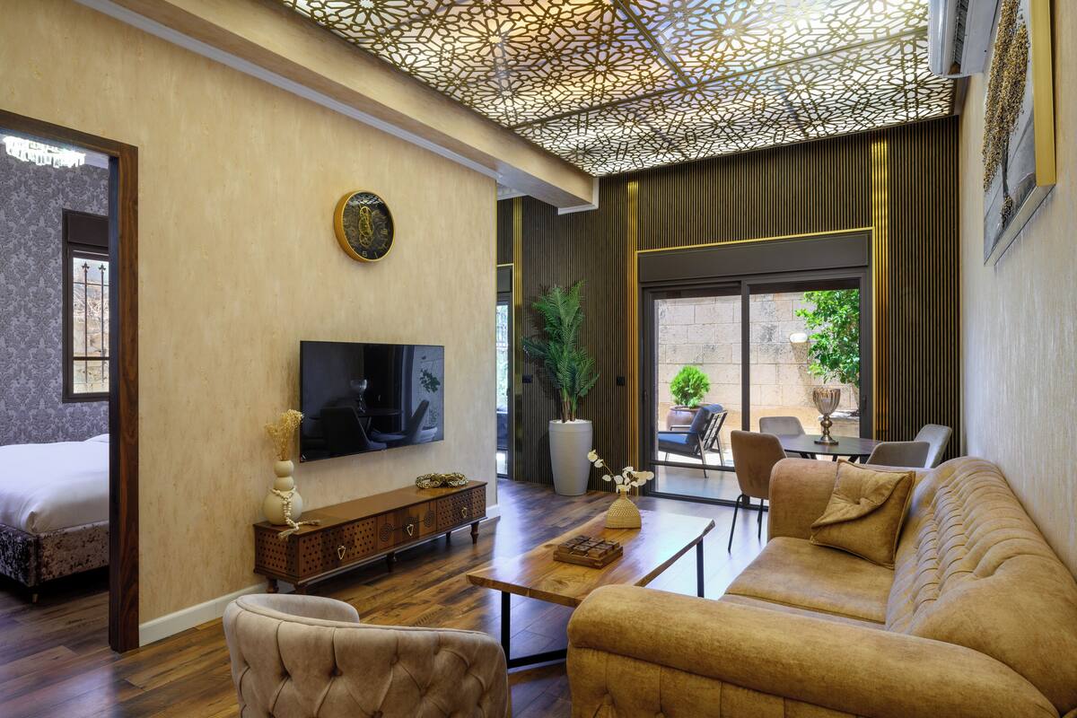 Un salon moderne comprenant un canapé, un fauteuil, un téléviseur et une console décorative.
