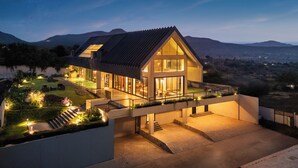 Una casa moderna con un balcón amplio, un interior luminoso y vistas del paisaje circundante.