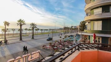 Een hotel met terras, uitzicht op het strand en een gebogen gevel.